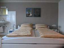 Bild vom Doppelbett vor grauer Wand